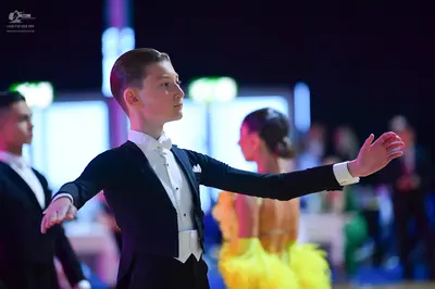 Dancesport competitor: Male dancer: black suit with white shirt, white bow tie, and white waistcoat