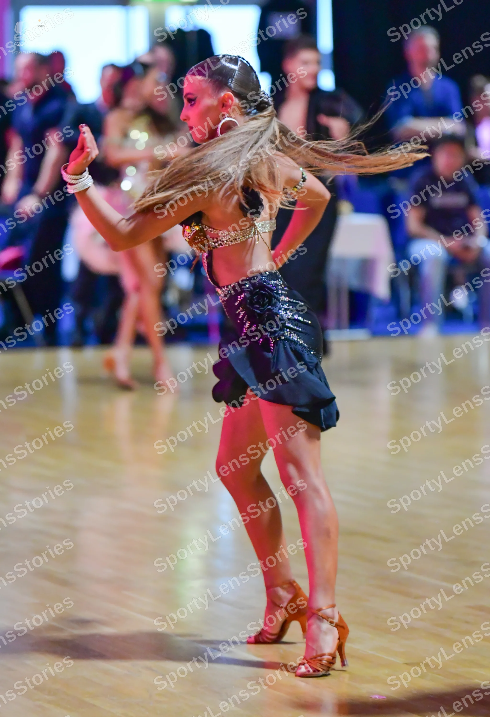 Dancesport competitor: Female dancer (foreground): dark latin dress with a beige/silver sequined top an