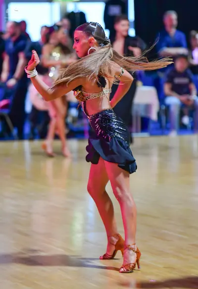 Dancesport competitor: Female dancer (foreground): dark latin dress with a beige/silver sequined top an
