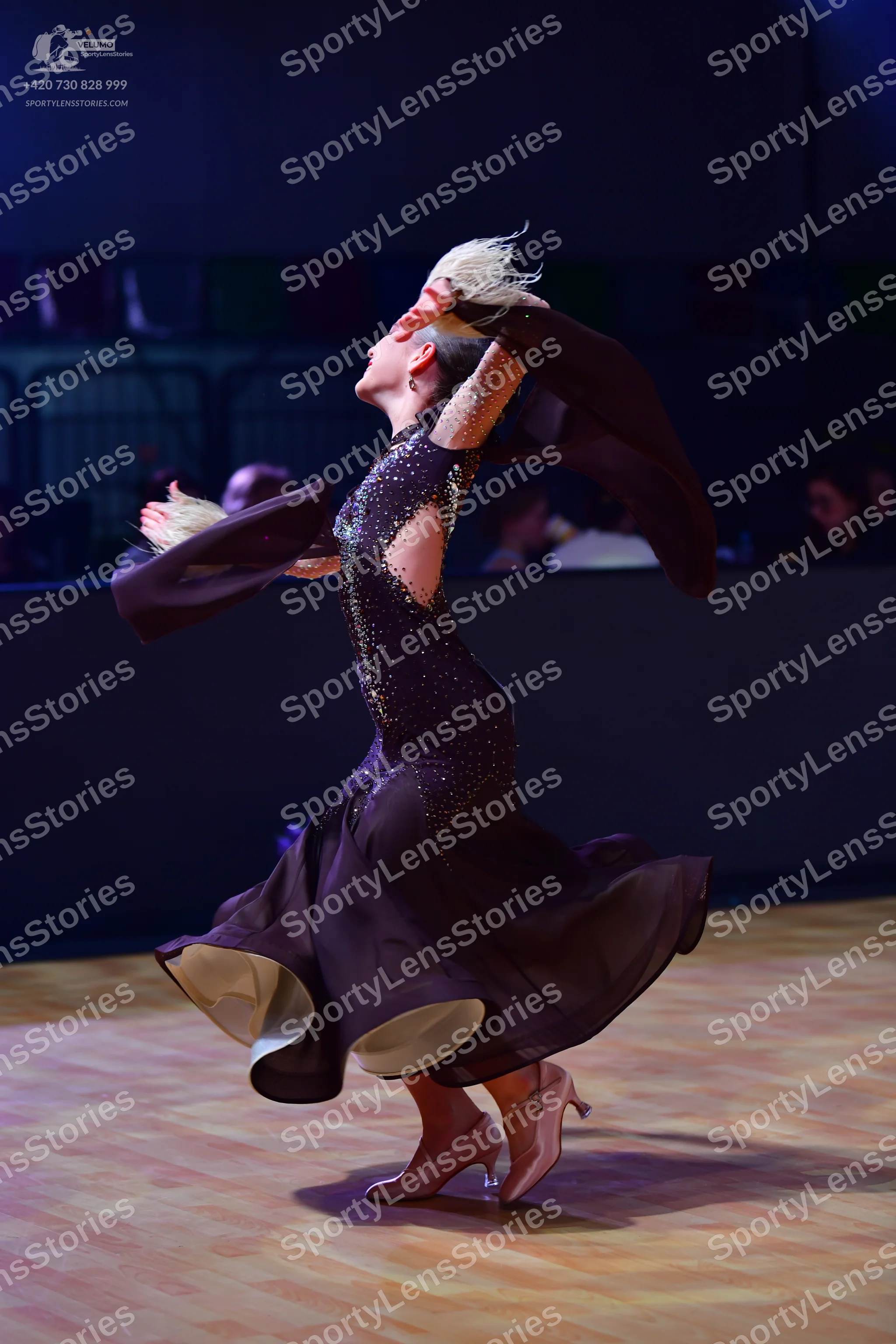 Dancesport competitor: Female dancer: black ballroom dress with a sequined bodice and a large, flowing 