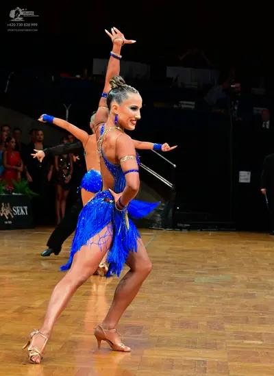 Dancesport competitor: Female dancer 1: blue latin dress with sequins and long blue fringe, and blue wr