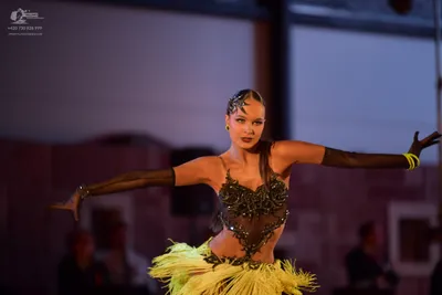 Dancesport competitor: Female dancer: dark, sheer Latin dance top with black sequins and embellishments