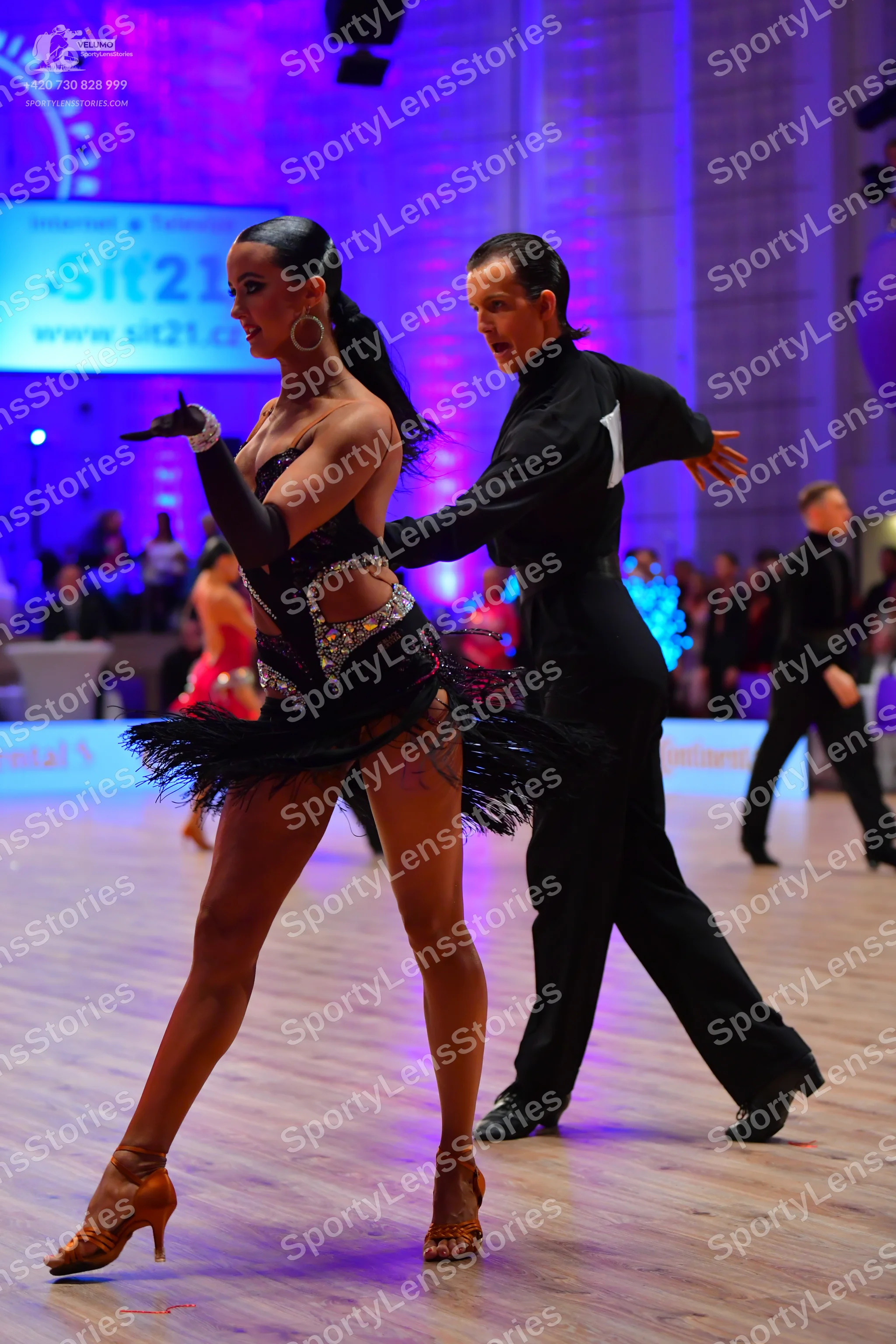 Dancesport competitor: Female dancer: black Latin dress with silver sequins and a black feather/fringe
