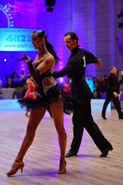 Dancesport competitor: Female dancer: black Latin dress with silver sequins and a black feather/fringe 