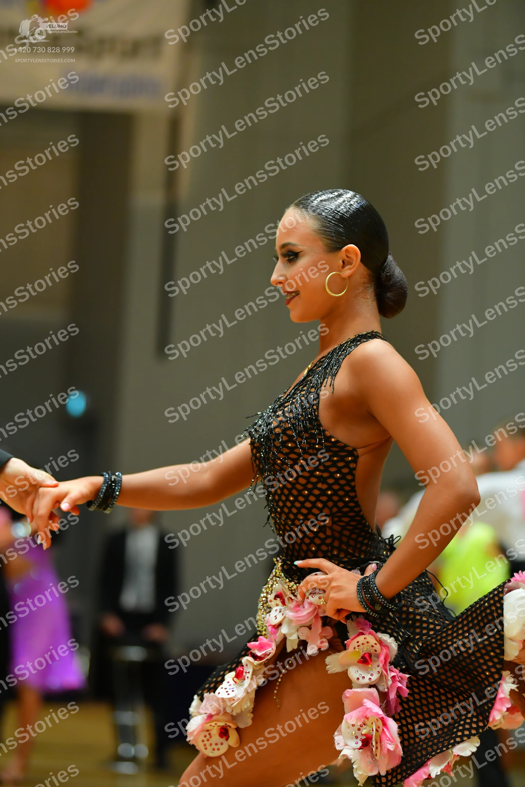 Dancesport competitor: Female dancer: black latin dress with a net-like mesh pattern, decorated with la
