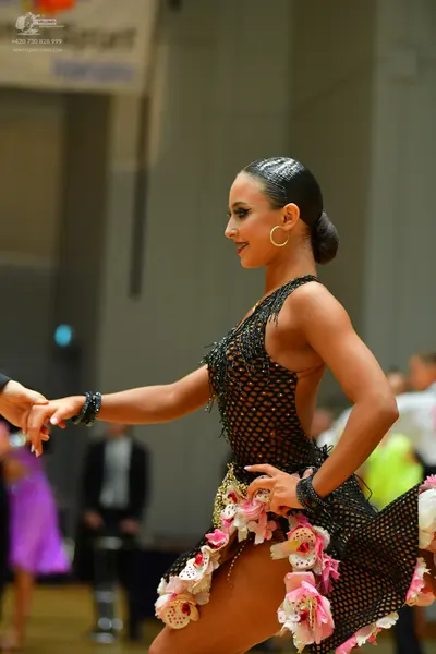 Dancesport competitor: Female dancer: black latin dress with a net-like mesh pattern, decorated with la
