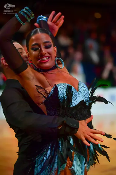 Dancesport competitor: Female dancer: light blue latin dress with black sequin details and large black 