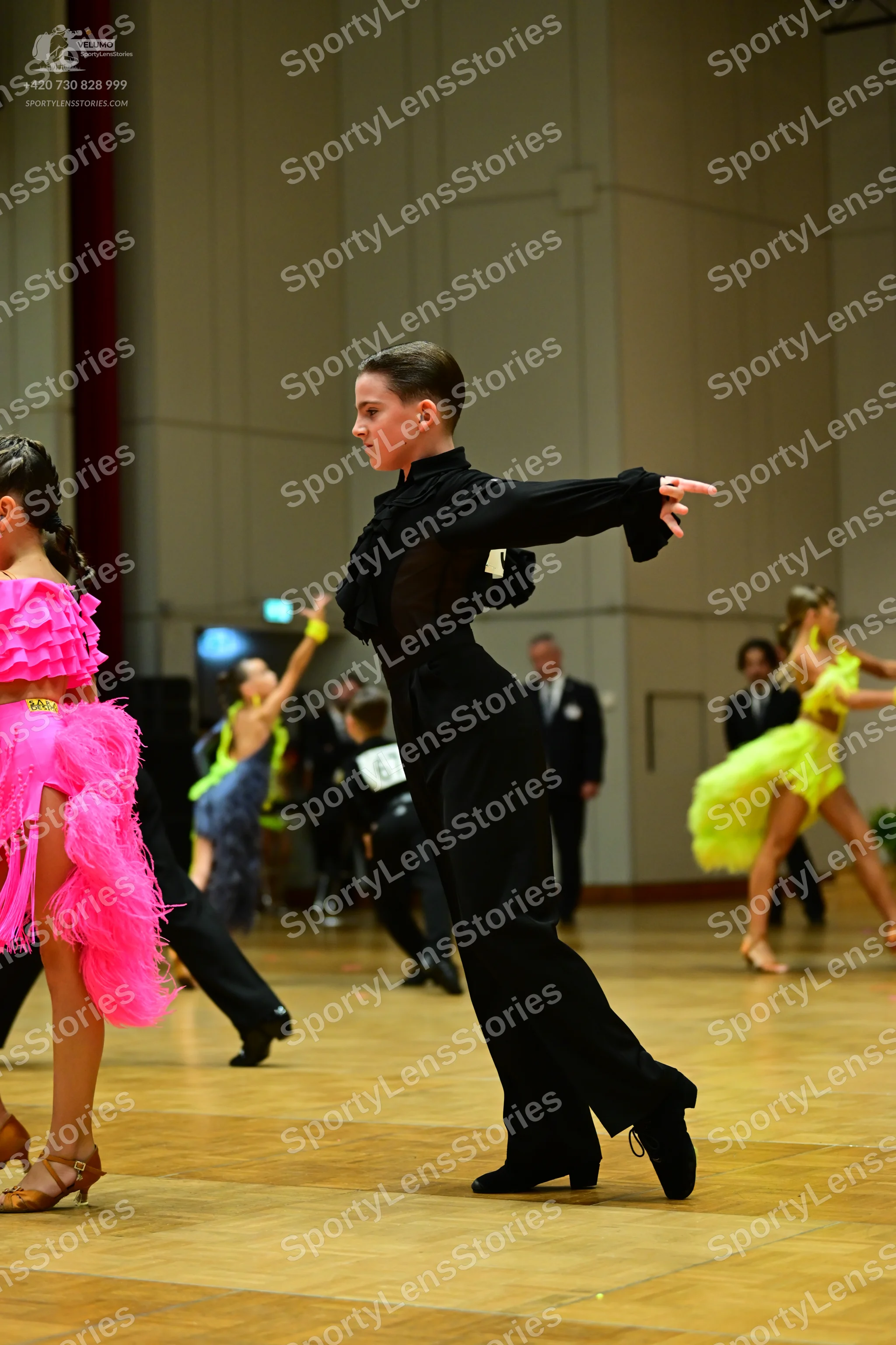 Dancesport competitor: Female dancer (foreground): bright pink latin dress with voluminous ruffles