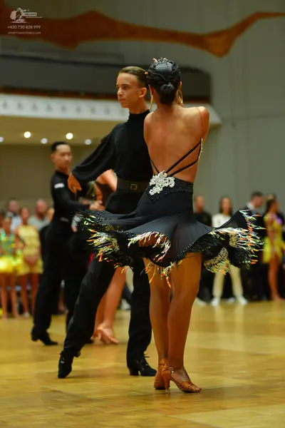 Dancesport competitor: Male dancer: black long-sleeved shirt and black trousers with a black belt