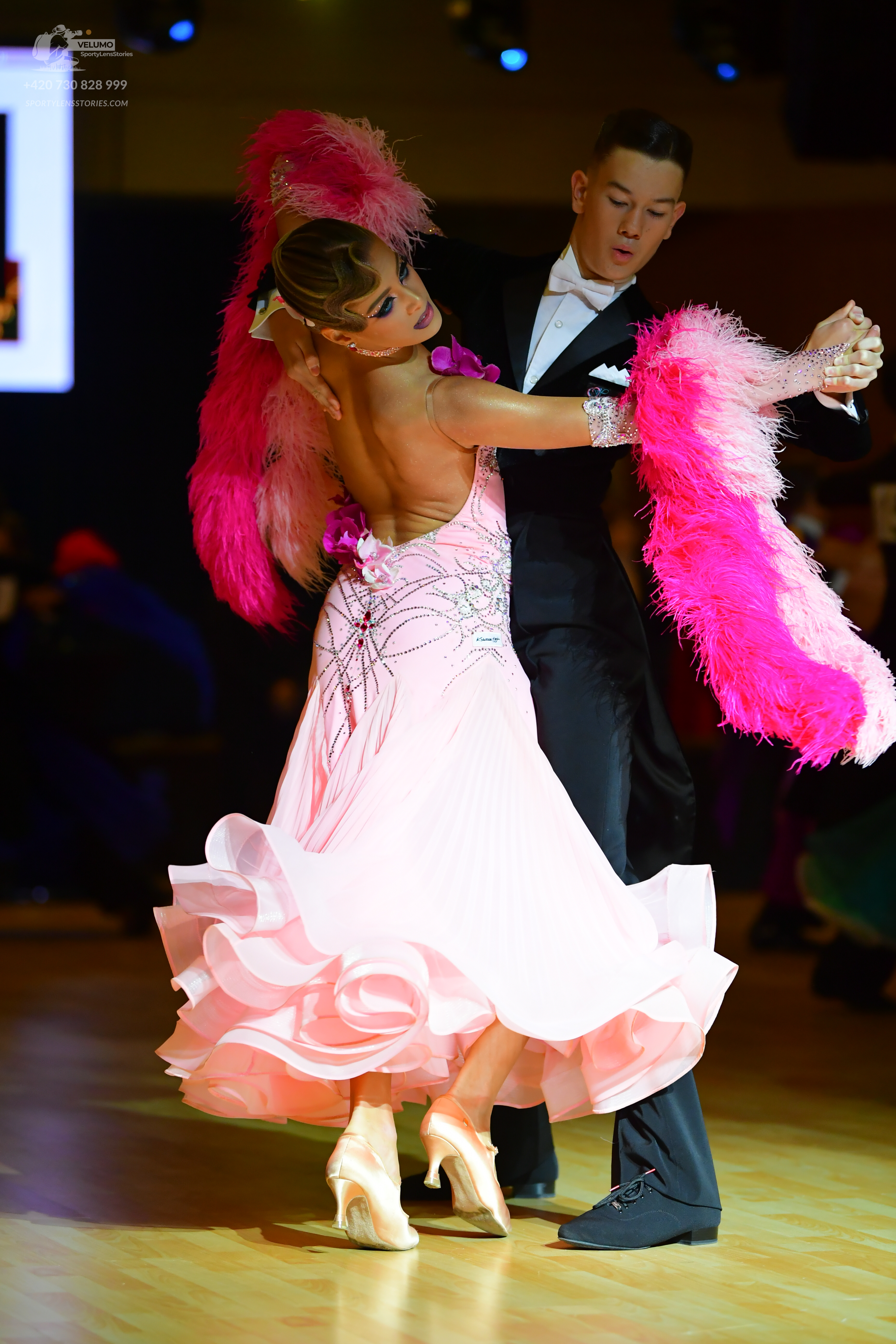 Dancesport competitor: Female dancer: light pink ballgown with a large ruffled skirt and sequined patte