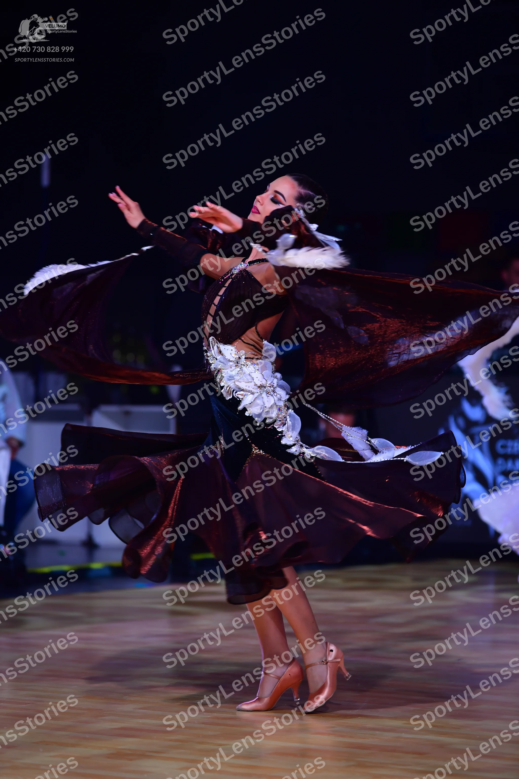 Dancesport competitor: Female dancer: dark burgundy-colored ballroom dress with a large, voluminous, fl