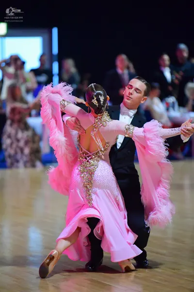 Dancesport competitor: Female dancer: light pink Latin dance dress with feathered sleeves and crystal/s