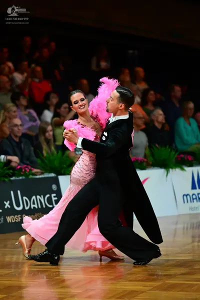 Dancesport competitor: Female dancer: pink sparkly ballroom gown with a large pink feathery/fluffy deco