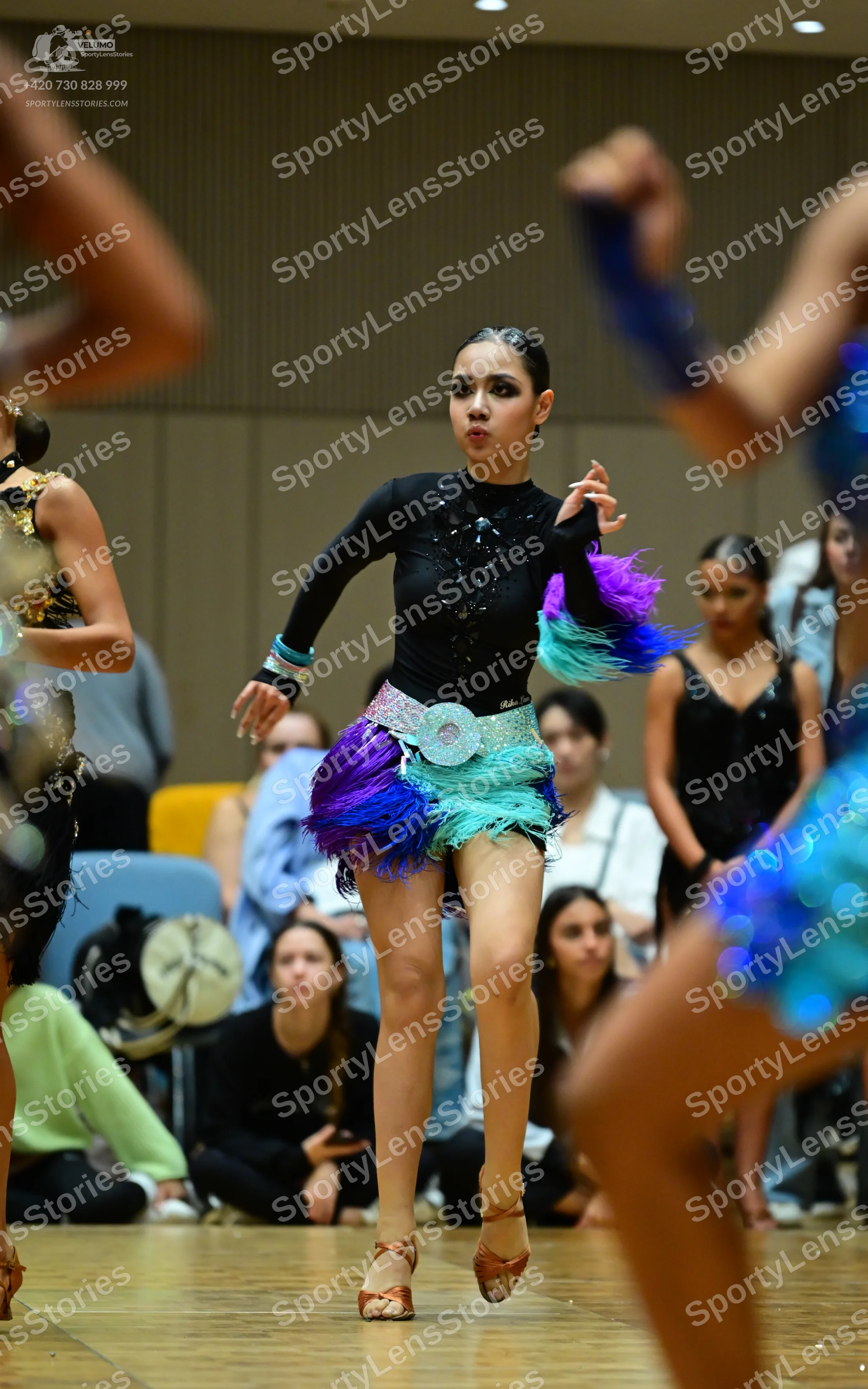Dancesport competitor: Female dancer (center): black long-sleeve latin dress with sequin embellishments