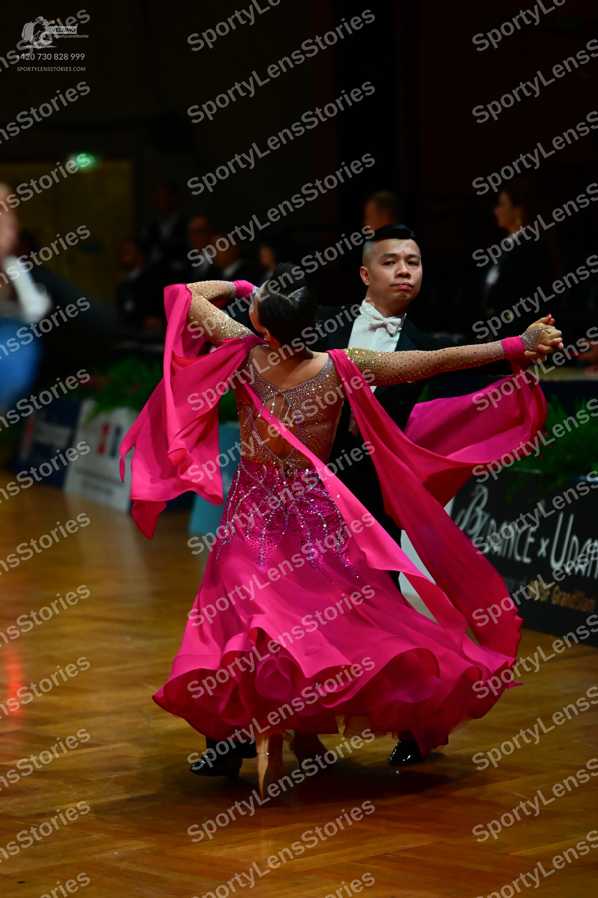 Dancesport competitor: Female dancer: bright pink ballroom dress with a sheer bodice decorated with sil