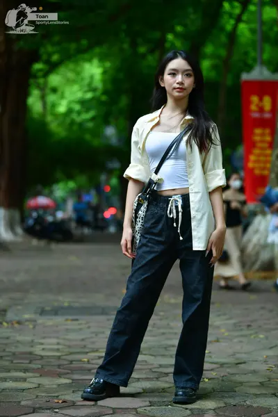 Dancesport competitor: Female dancer: white tank top, cream-colored unbuttoned long-sleeve shirt, and b