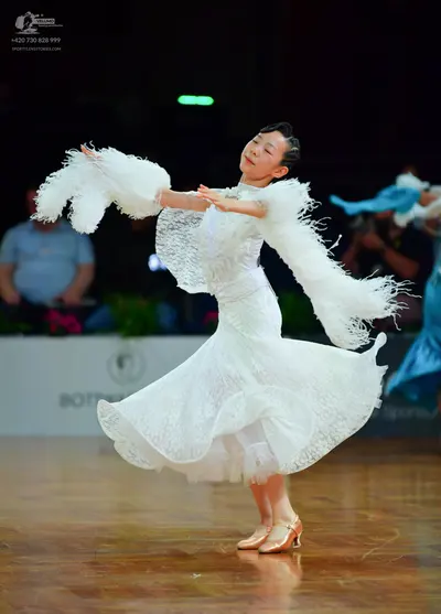 Dancesport competitor: Female dancer: white ballroom dress with lace bodice and skirt, featuring long s