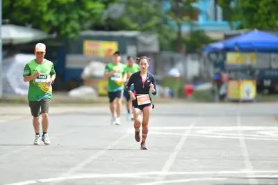 Marathon runner #5461, #5365: Runner 1: green jersey, grey shorts, white shoes, orange cap