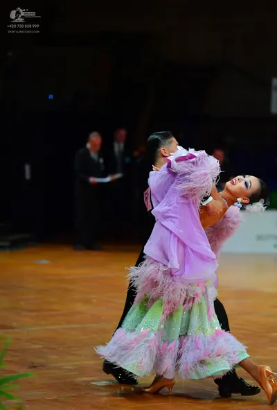 Dancesport competitor: Female dancer: light purple/lavender ballroom gown with extensive feather or fri