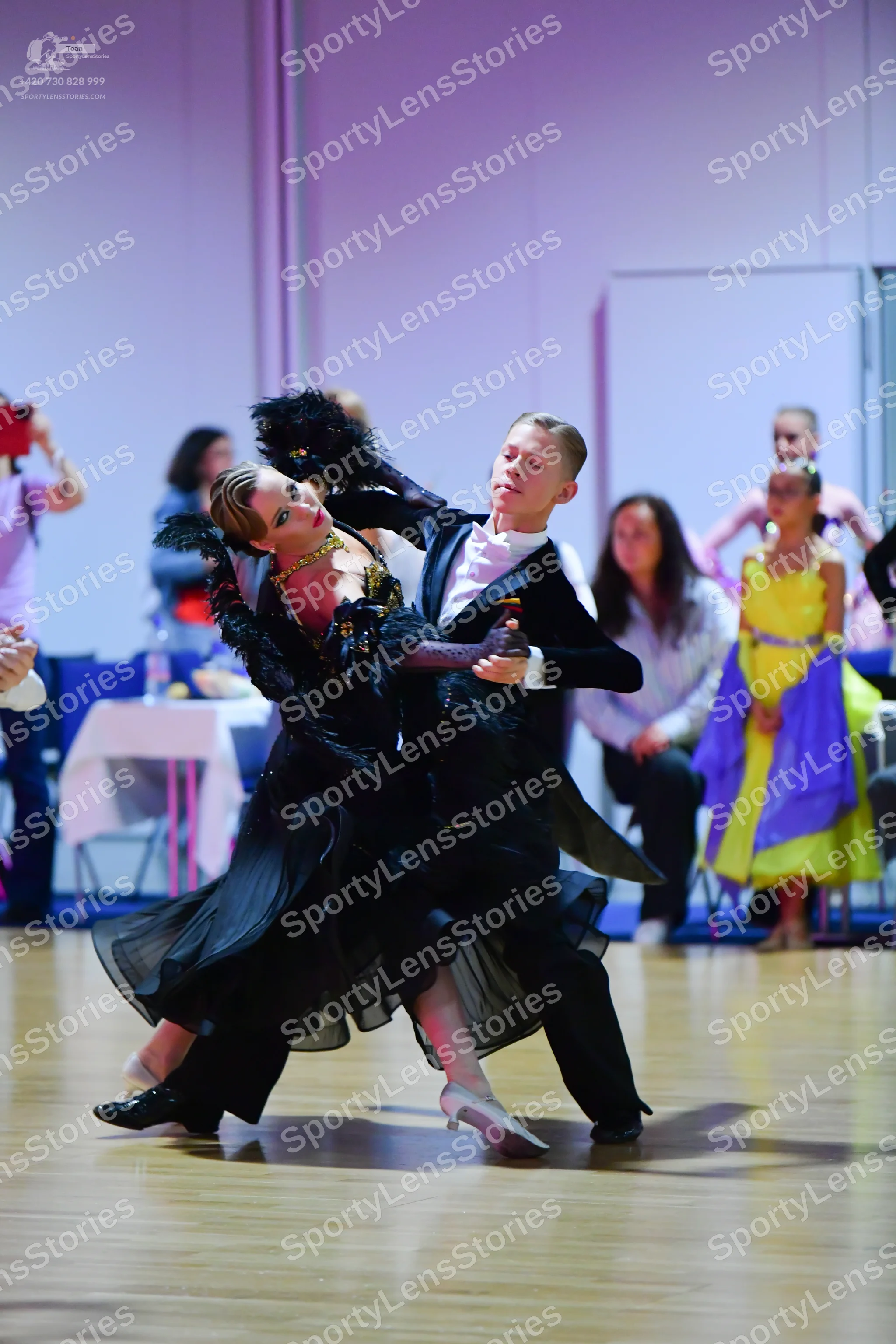 Dancesport competitor: Female dancer: black ballroom dress with a textured bodice, large voluminous she