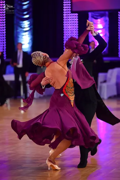 Dancesport competitor: Female dancer: purple Latin dance dress with a ruffled skirt and decorative oran