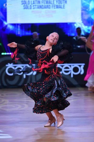 Dancesport competitor: Female dancer: black latin dress with red polka dots, red sequined or beaded pat