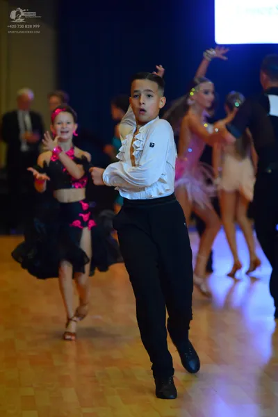 Dancesport competitor: Male dancer: white long-sleeved shirt with ruffles on the front and black trouse