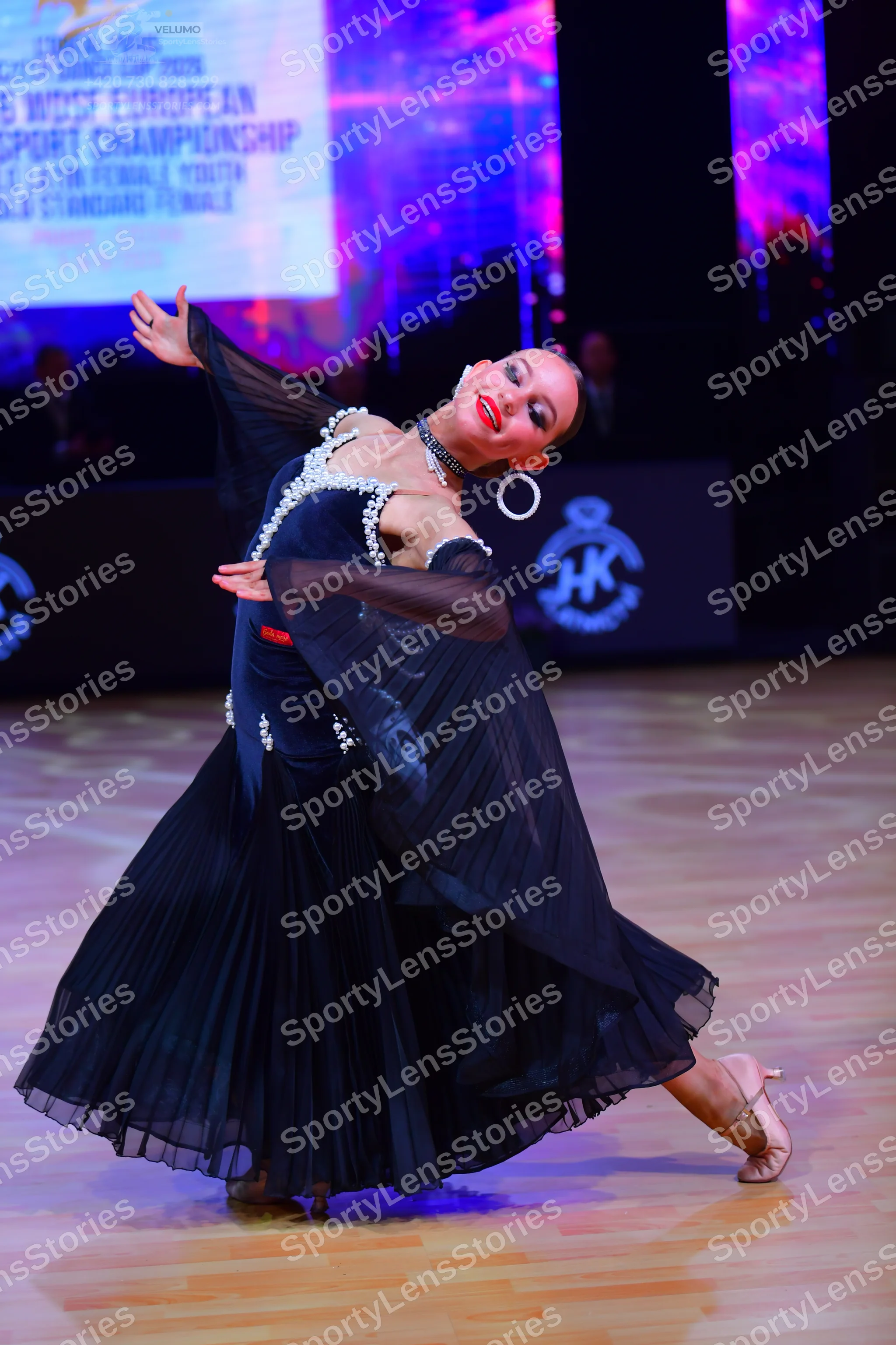 Dancesport competitor: Female dancer: dark navy ballroom dress with silver sequin embellishments on the