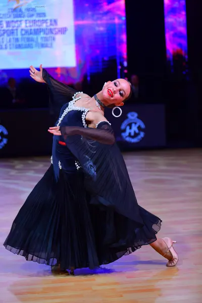 Dancesport competitor: Female dancer: dark navy ballroom dress with silver sequin embellishments on the
