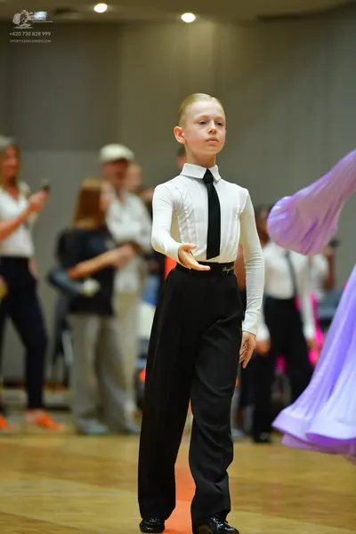 Dancesport competitor: Male dancer: white long-sleeved shirt, black necktie, and black trousers