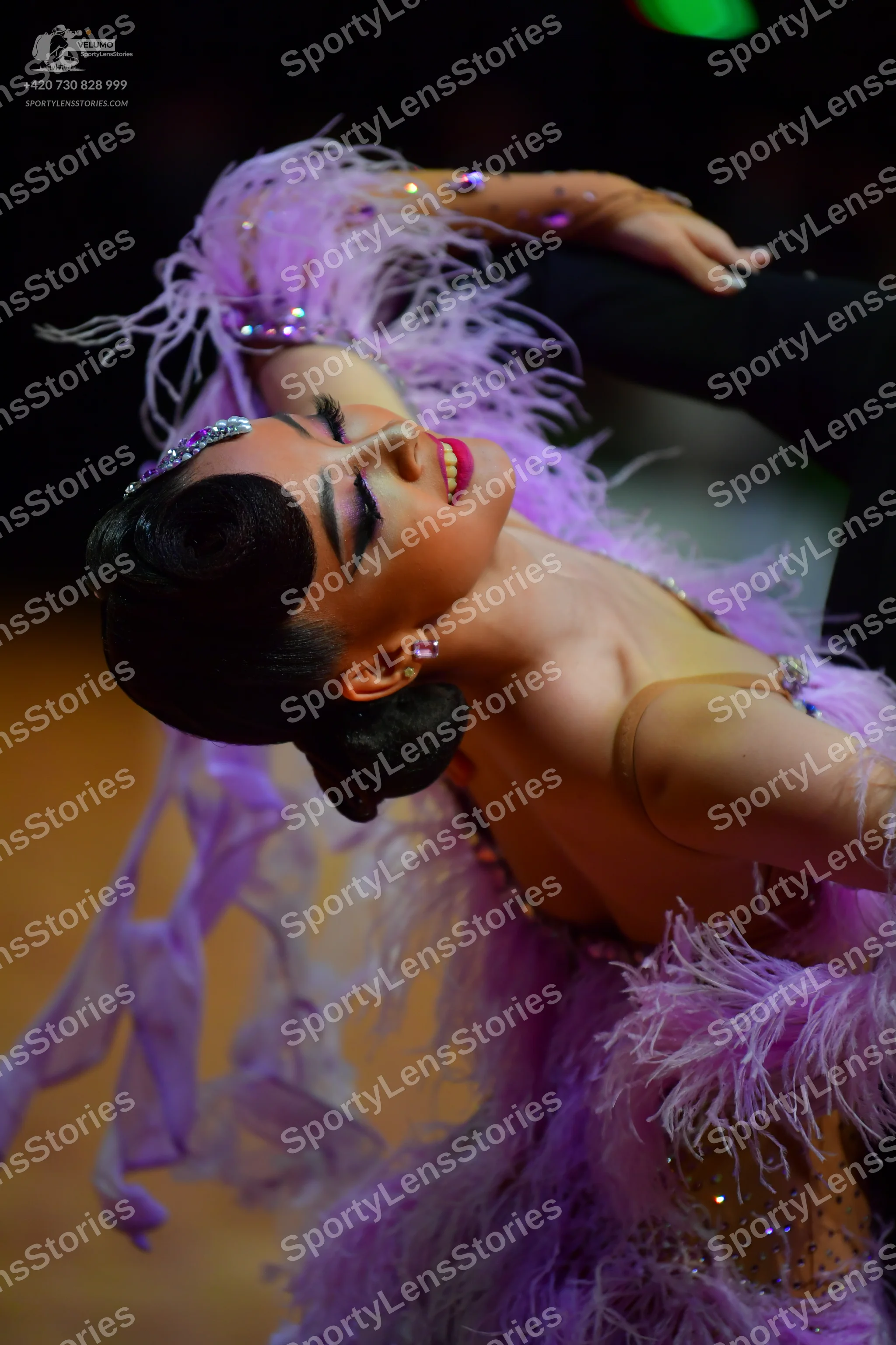 Dancesport competitor: Female dancer: light purple Latin dance dress featuring long lavender feathers, 