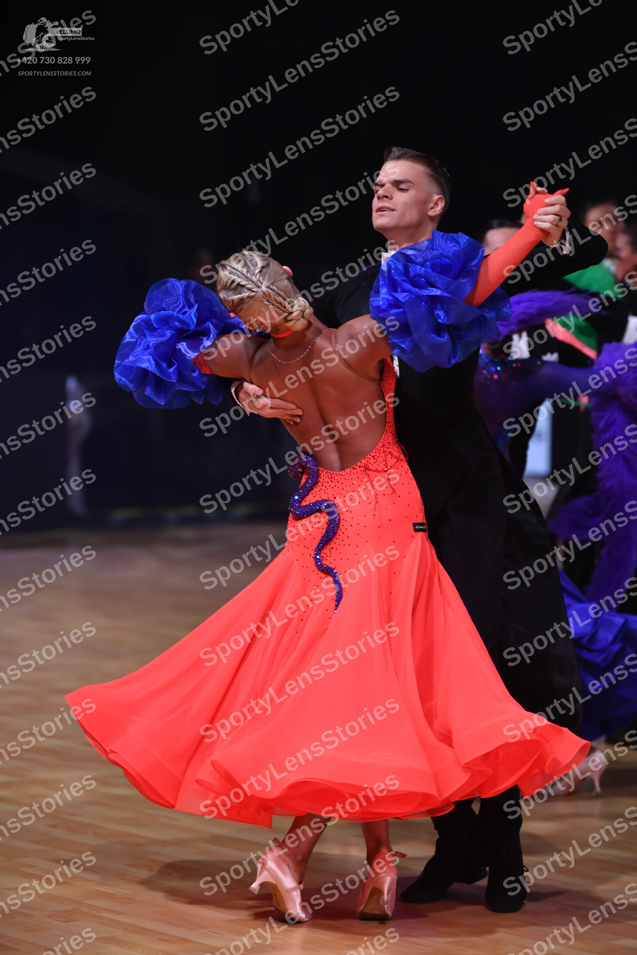 Dancesport competitor: Female dancer: red ballroom gown with a voluminous skirt, blue/purple sequin det
