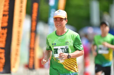 Marathon runner #61: Runner 1: green jersey with yellow patterns, white and orange cap, black watch