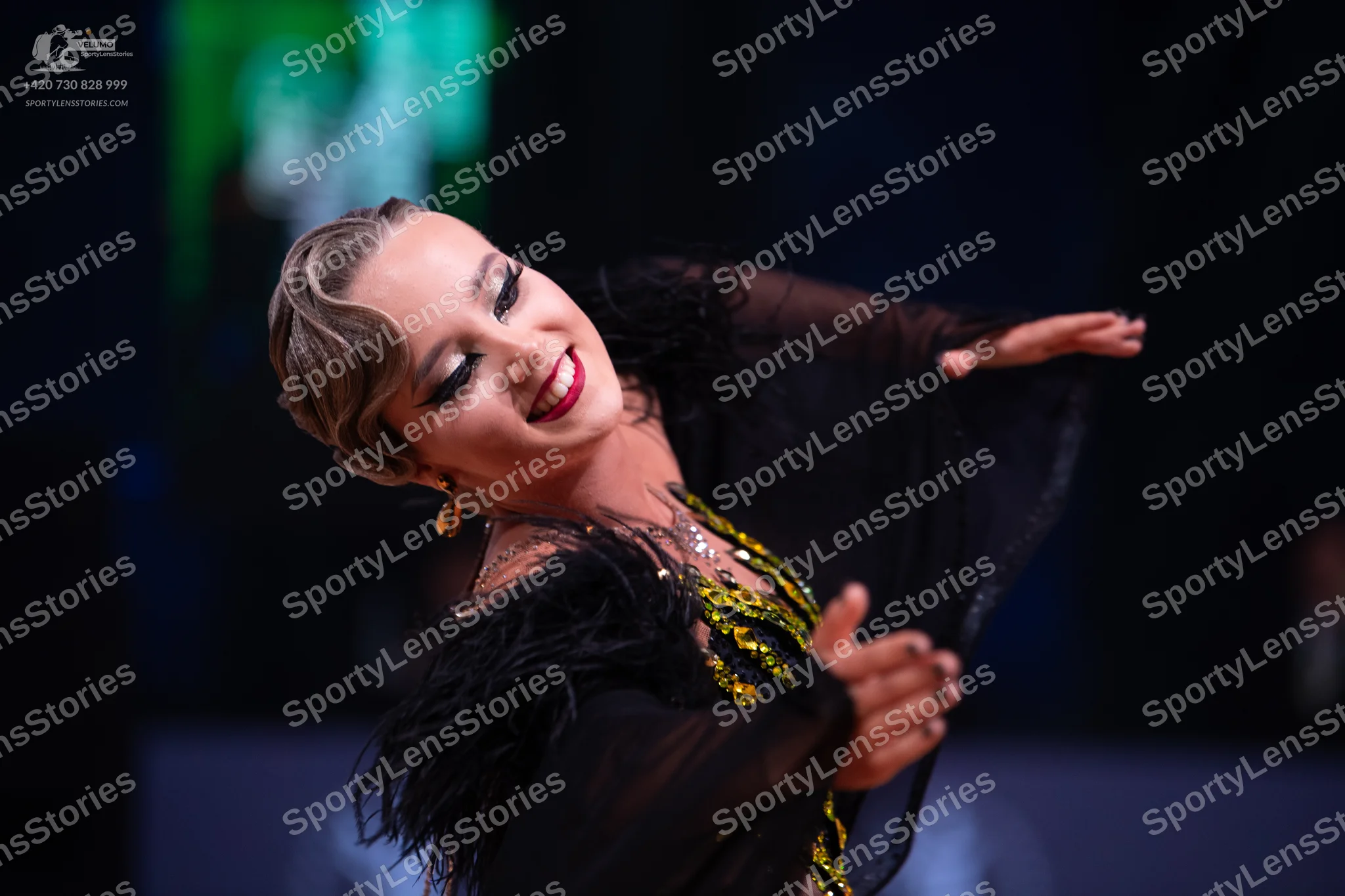 Dancesport competitor: Female dancer: black latin dress with gold and green sequin/beaded details, blac