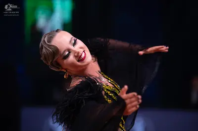 Dancesport competitor: Female dancer: black latin dress with gold and green sequin/beaded details, blac