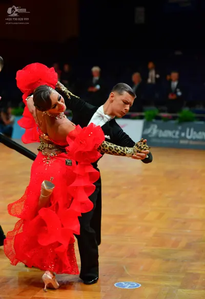 Dancesport competitor: Female dancer: red Latin dress with large ruffles and leopard print long sleeves