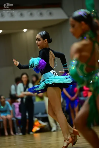 Dancesport competitor: Female dancer: black long-sleeved Latin dance dress with an open back and a mult