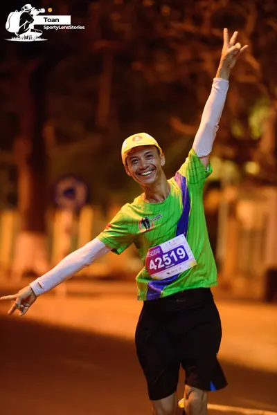 Marathon runner #42519: Runner 1: lime green jersey with purple accents, white arm sleeves, black shorts