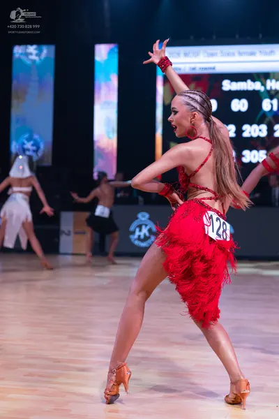 Dancesport competitor: Main female dancer: red latin dress with fringe and red accessories
