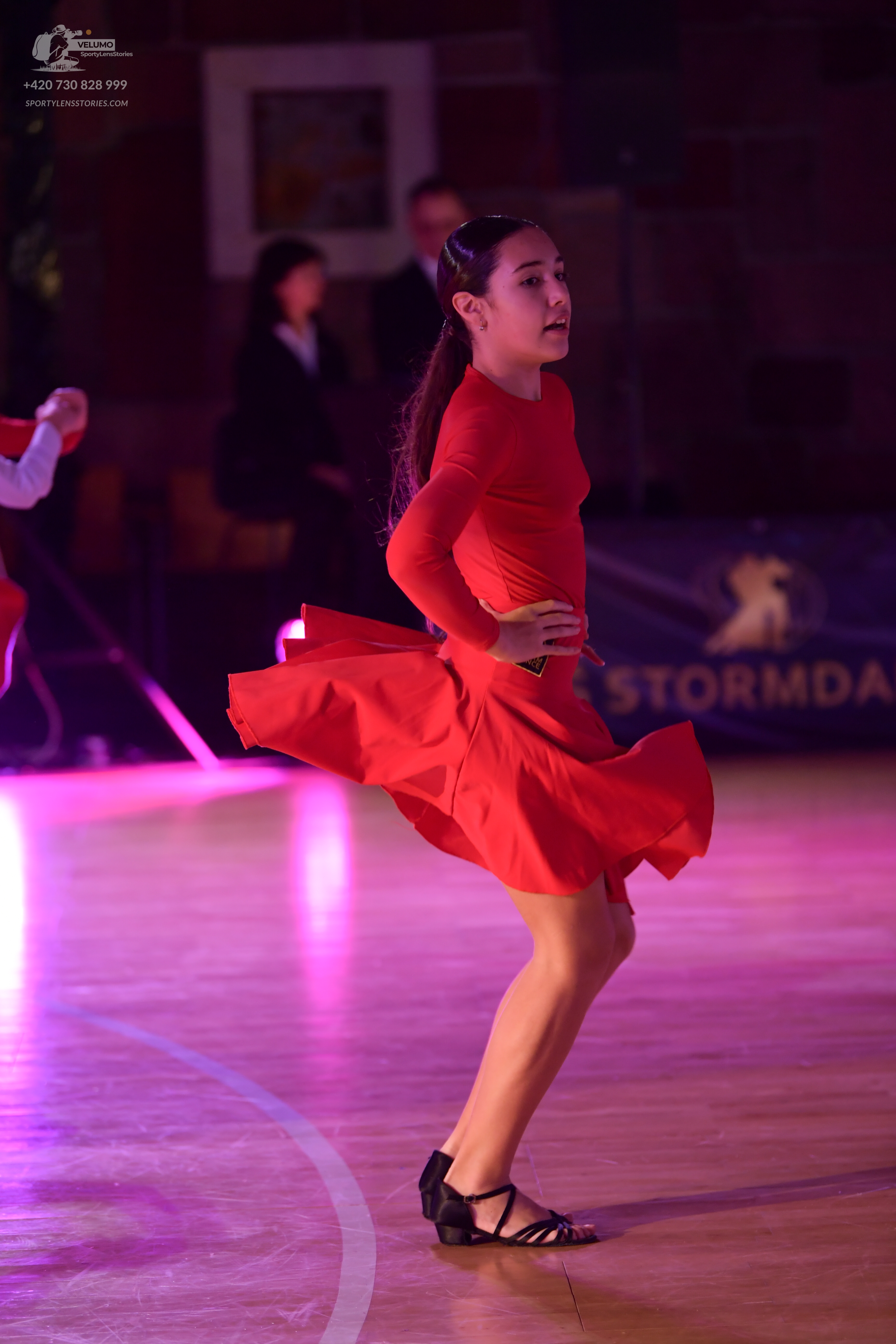 Dancesport competitor: Female dancer: red long-sleeved Latin dress with a flared skirt