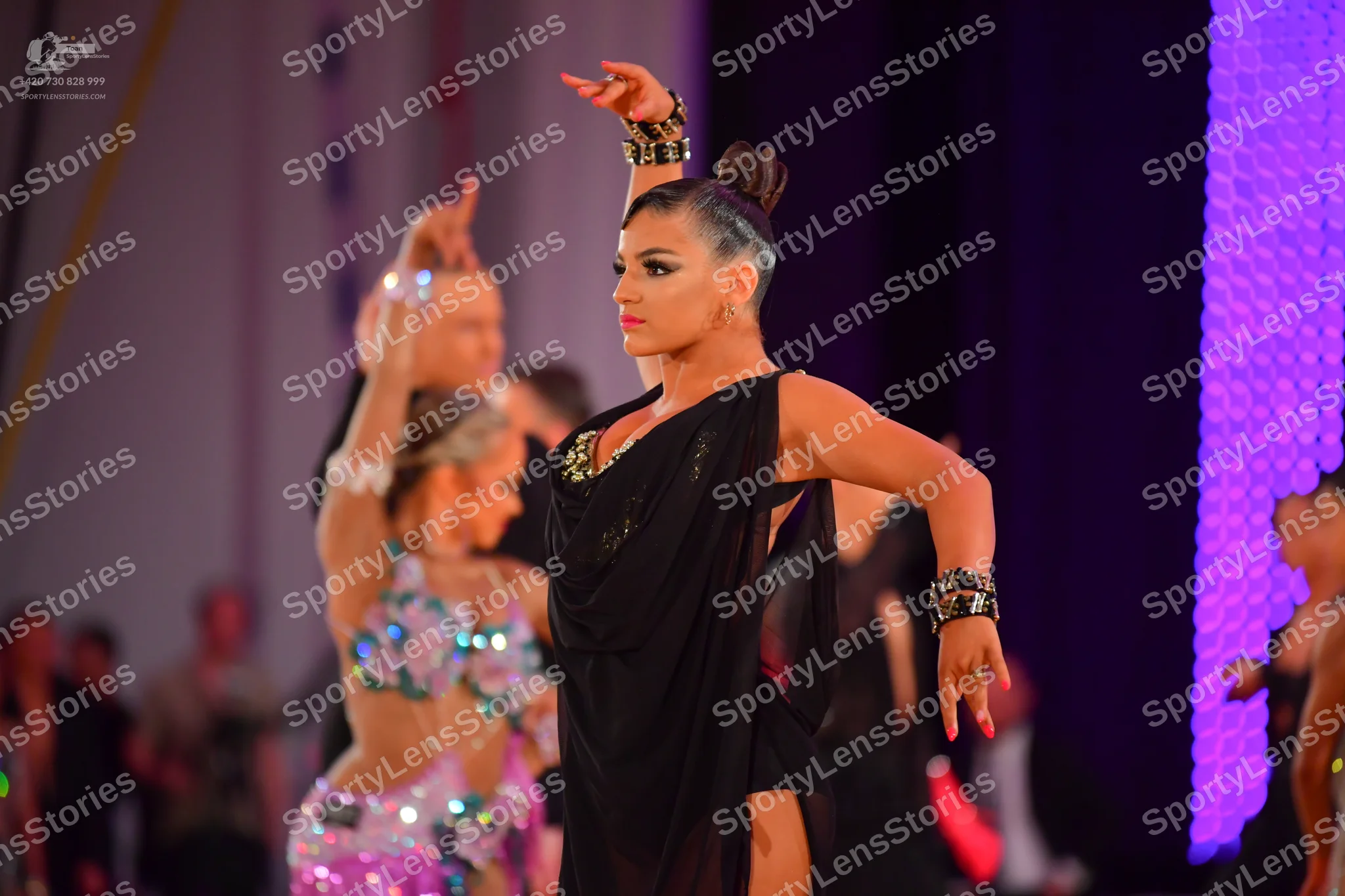 Dancesport competitor: Main female dancer: black latin dress with a one-shoulder design featuring sequi