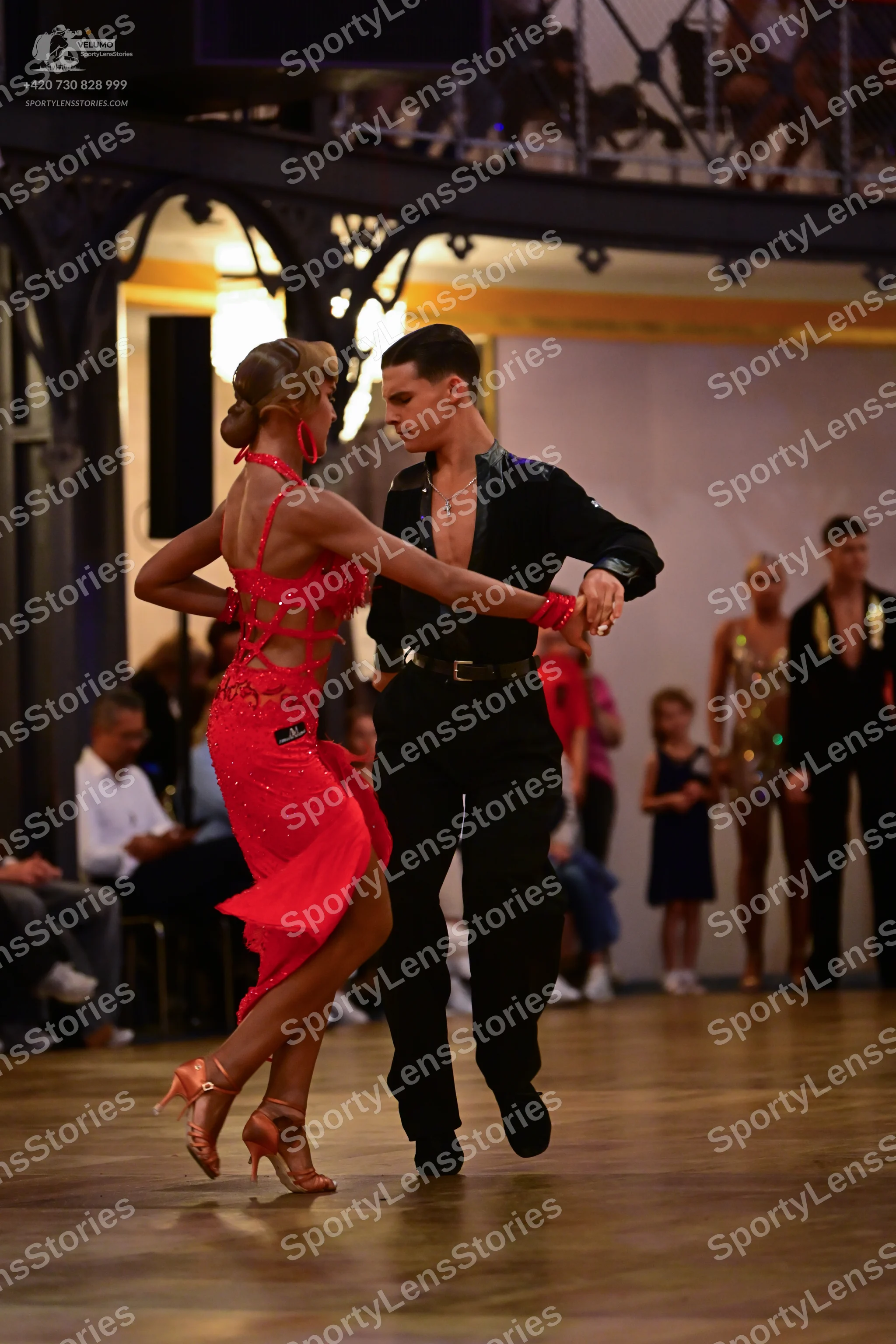 Dancesport competitor: Female dancer: red Latin dress with cutouts and nude-colored dance heels