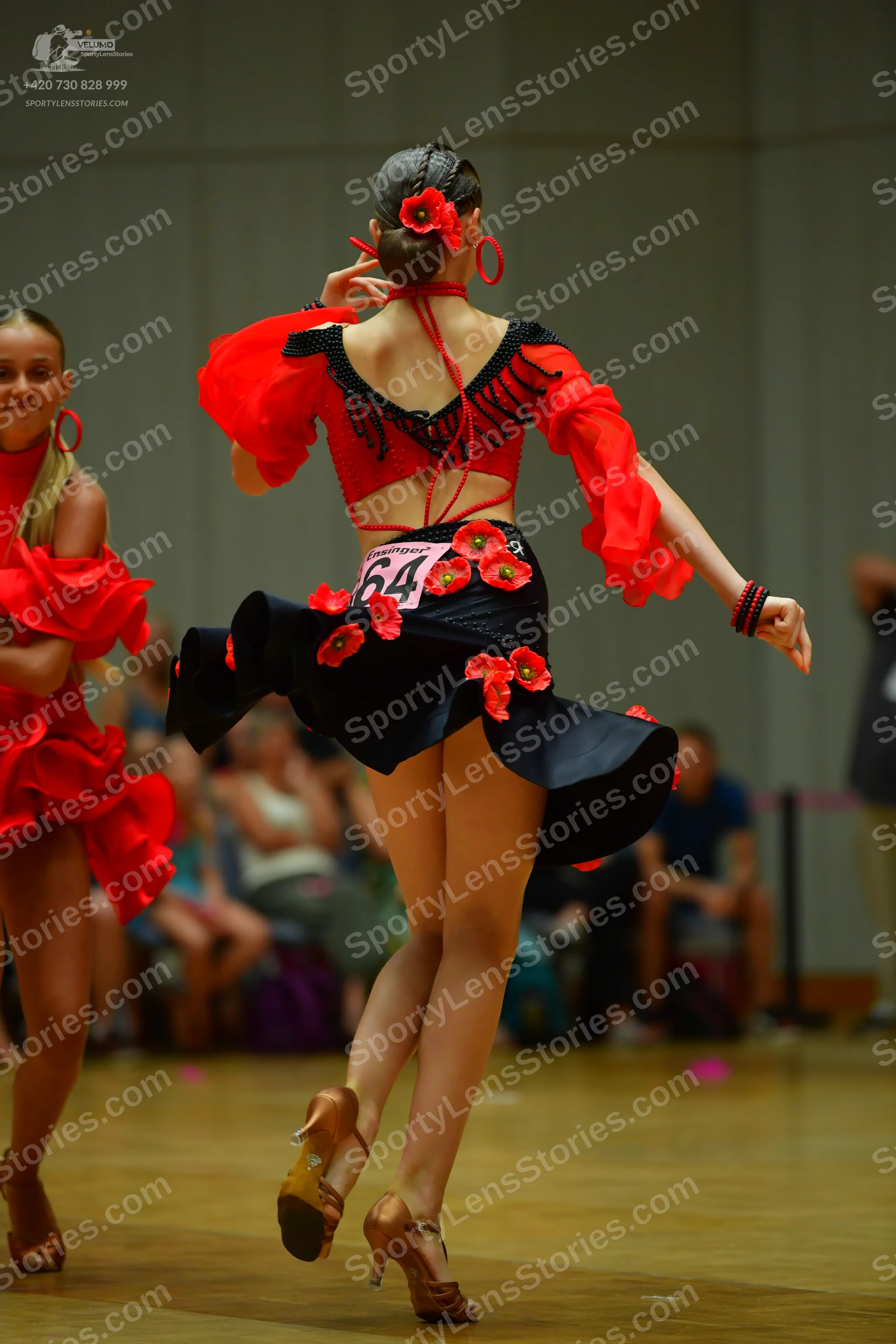 Dancesport competitor #64: Female dancer 1: red and black latin dress with black fringe on the sleeves and 