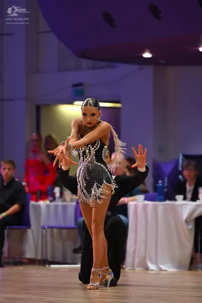 Dancesport competitor: Female dancer: black Latin dress embellished with silver sequins and long silver