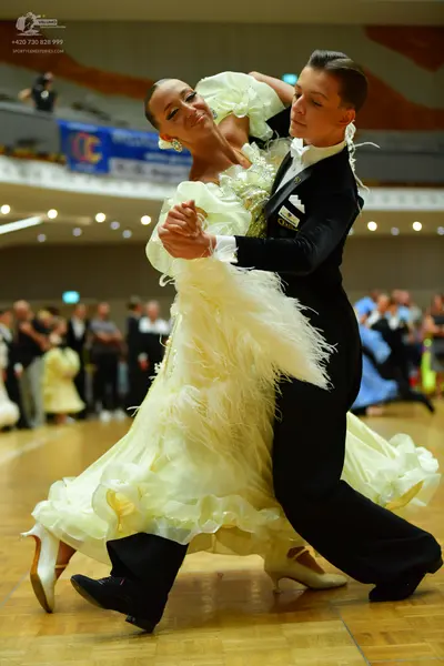 Dancesport competitor: Male dancer: black suit with white detailing on the collar and lapels, paired wi
