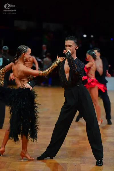 Dancesport competitor: Male dancer: black long-sleeved shirt with lace/patterned fabric and black trous