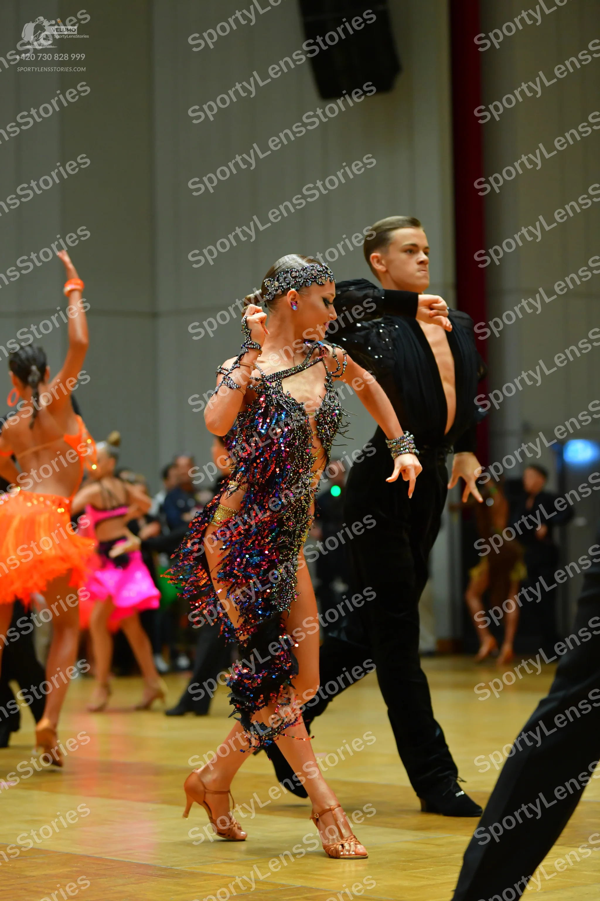 Dancesport competitor: Main female dancer: multi-colored sequined Latin dress with fringe and thin stra