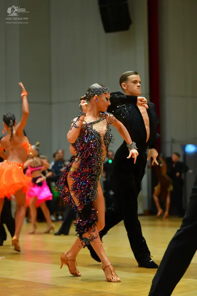 Dancesport competitor: Main female dancer: multi-colored sequined Latin dress with fringe and thin stra
