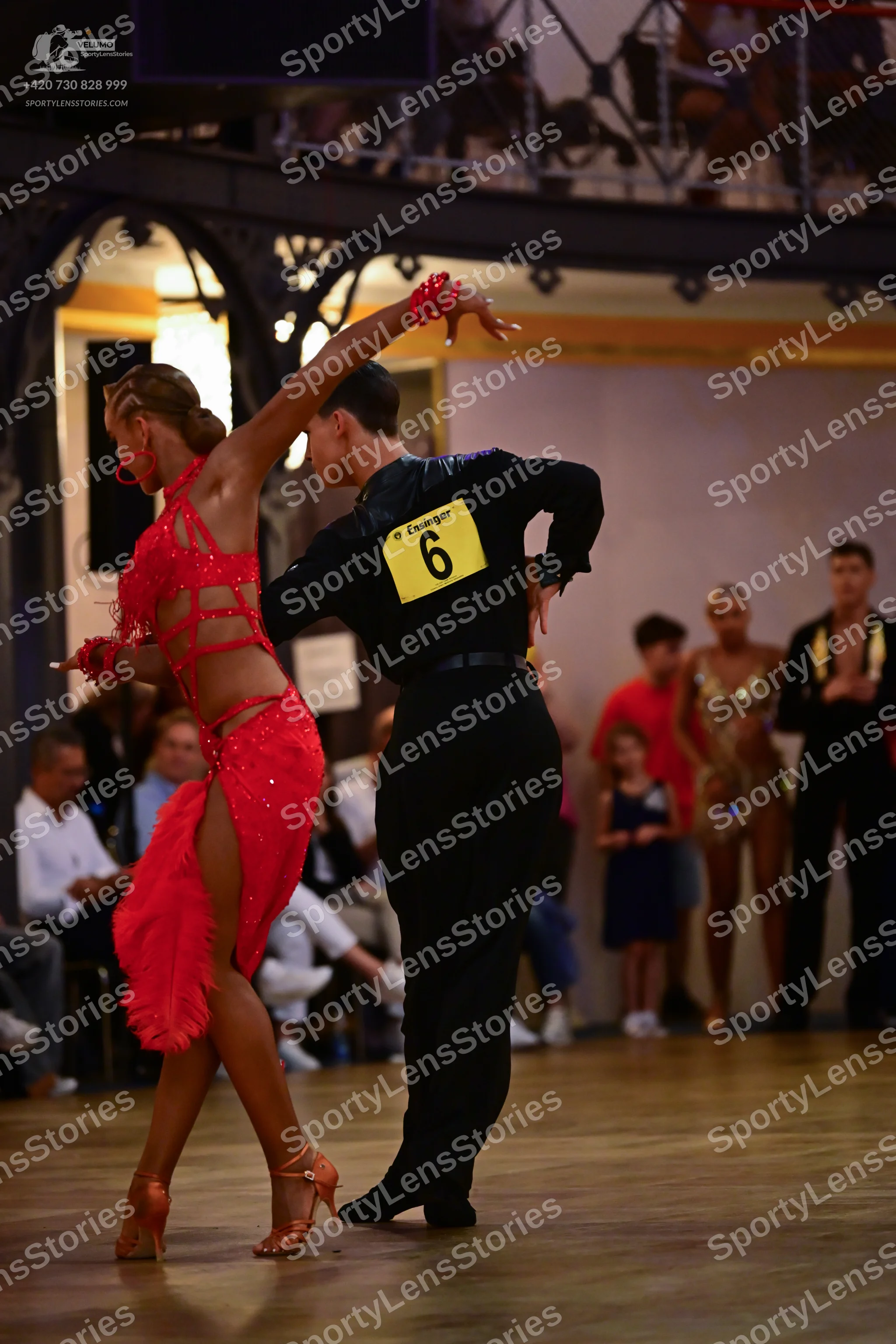 Dancesport competitor: Female dancer: red latin dress with sequins and mesh panels, matching red wristb