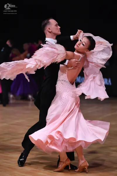 Dancesport competitor: Male dancer: black suit with a white shirt collar and black patent leather shoes